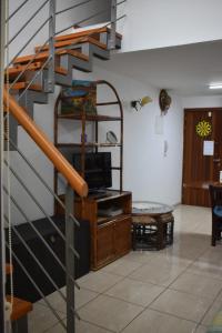 a living room with a spiral staircase with a tv at Marina Apartment 4 in Larnaka