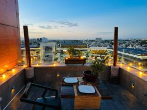 a balcony with two tables and a view of a city at Zújmú Business Boutique Hotel in Aguascalientes