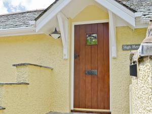 una porta di legno sul lato di una casa di High Mere a Windermere