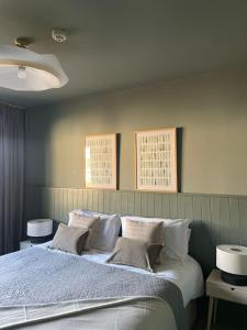 ein Bett in einem Schlafzimmer mit zwei Bildern an der Wand in der Unterkunft Doonmore Hotel, Bar & Restaurant in Inishbofin