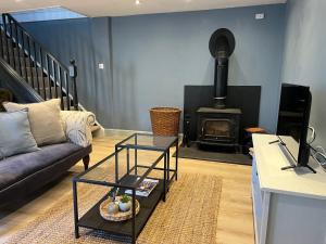 a living room with a couch and a stove at The Barn in Saxmundham