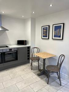 a kitchen with a wooden table and two chairs at The Barn in Saxmundham