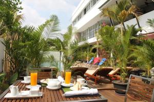 un patio con una mesa con comida y zumo de naranja en MEN's Resort & Spa (Gay Hotel), en Siem Reap