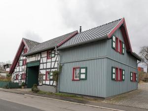 a green and white house with red windows at Schleiden Timber-Frame Retreat in Schleiden +32 photos