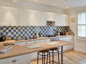 a kitchen with white cabinets and a wooden counter top at Nautilus Cottage in Cellardyke