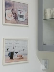 dos cuadros enmarcados en una pared con una taza de café en Cinege Apartman en Felsőpáhok