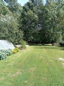 un jardín con invernadero en medio de un campo en Cinege Apartman en Felsőpáhok