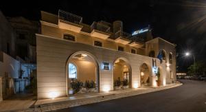 a building with arches and lights at night at Hotel Aurora del Benessere in Santa Cesarea Terme