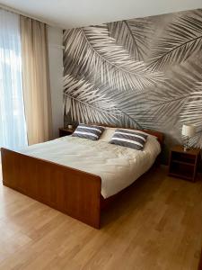 um quarto com uma cama grande e uma parede com um mural em Apartmani HILA em Njivice
