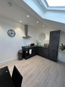 une salle avec un comptoir et une horloge sur le mur dans l'établissement Modern London Apartment, à Londres