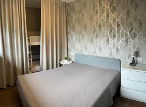 a bedroom with a bed and a wall at Tulbi Apartment in Pärnu