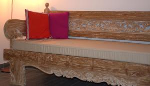 a wooden bench with two pillows on it at Villa Le Jacaranda in Salazie