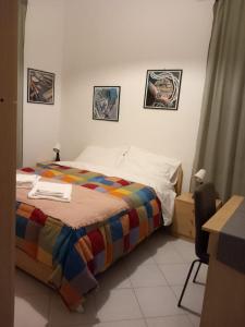 ein Schlafzimmer mit einem Bett und einem Schreibtisch mit einem Stuhl in der Unterkunft Parmigiana in Levanto