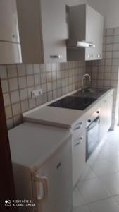 a white kitchen with a sink and a counter at Parmigiana in Levanto