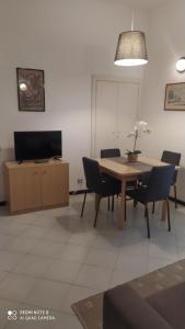 ein Esszimmer mit einem Tisch, Stühlen und einem TV in der Unterkunft Parmigiana in Levanto