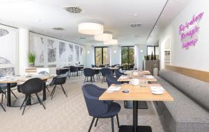 a restaurant with tables and chairs in a room at Gasthof zum Bad in Langenau