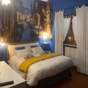 a bedroom with a bed with a painting of a city at Stenghe Stracche in Ascoli Piceno