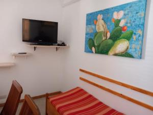 Habitación con TV de pantalla plana en la pared en Casa del Vento, en Lipari