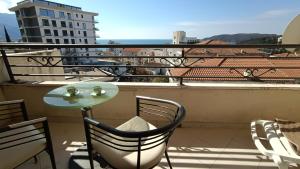 a table and chairs on a balcony with a view at Nossa Casa in Bečići