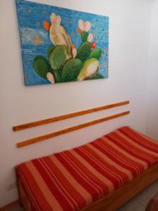 uma cama num quarto com uma pintura na parede em Casa del Vento em Lipari