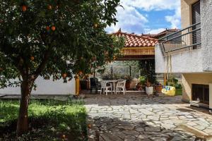une terrasse avec un oranger, une table et des chaises dans l'établissement Nice house in Euboea, à Politiká