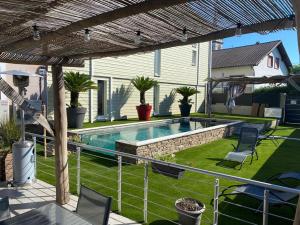 a backyard with a swimming pool and a house at Auberge des Sauterelles in Sermersheim