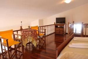 a living room with a table and chairs and a television at Nice house in Euboea in Politiká