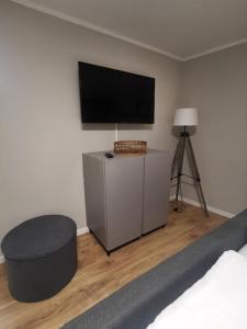 a bedroom with a bed and a tv and a stool at Ferienhaus zur Weinfee in Briedel