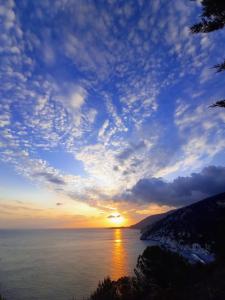 a sunset over a body of water with the sun setting at Villa La Pila Bilo in Marina di Campo +5 photos
