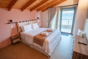 una camera da letto con un grande letto con una grande finestra di Villa Athina a Preveza