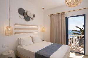 sypialnia z łóżkiem i widokiem na ocean w obiekcie Hotel Sunshine w mieście Kamari