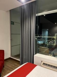 a bedroom with a bed and a large window at Zújmú Business Boutique Hotel in Aguascalientes