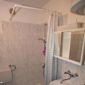 a bathroom with a shower curtain and a sink at Apartments Anita in Veli Lošinj