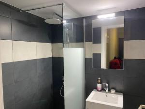 uma casa de banho com um lavatório e um espelho em Cozy new apartment near the beach em Atenas