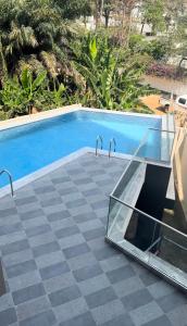 a swimming pool with a glass table next to it at Studio Apartment in Accra