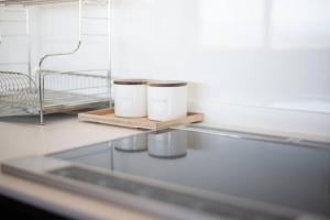 deux tasses assises sur une étagère dans une pièce dans l'établissement BLUE ARK, à Izu