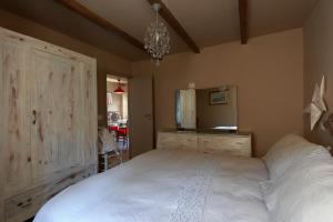 - une chambre avec un grand lit blanc et une commode dans l'établissement appartamento di classe nel castello di Panicale, à Panicale