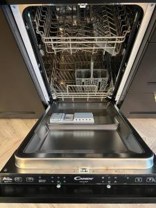 a dishwasher with its door open with dishes in it at Luxury Apartment In The City Center , Wi-Fi - by HIK Apartments in Warsaw