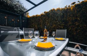 a table with glasses and a bottle of wine on it at Villa Moderne avec Jacuzzi proche d'Avignon in Le Thor