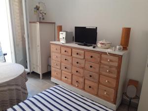 een slaapkamer met een dressoir en een televisie bij PETIT BONHEUR Au COEUR DU VIEUX PORT in Marseille