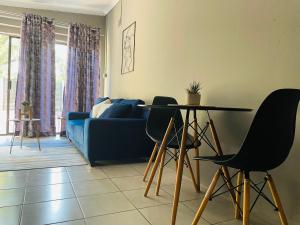 a living room with a table and a blue couch at Solace Unit in Phalaborwa