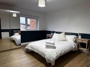 a bedroom with a bed with towels on it at 3 Bedroom/3 Bathroom Large Flat Near OVO Hydro in Glasgow