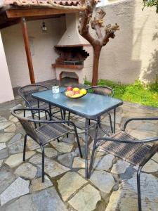 una mesa y sillas con un bol de fruta. en Anna's House en Anavyssos