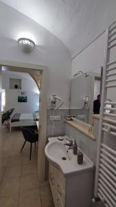 uma casa de banho com um lavatório e um espelho em Ninetta Mia em Alessano