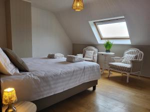 a bedroom with a bed and two chairs and a window at Villazzo in Ghent