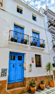 コンペタにあるCasa La Piedraの白い建物(青いドア、バルコニー付)
