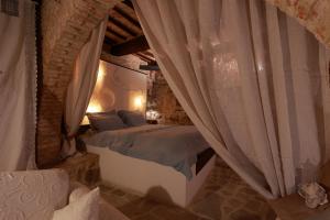 La Casina Del Lillotatini في بانيكالي: غرفة نوم بسرير وستائر في غرفة