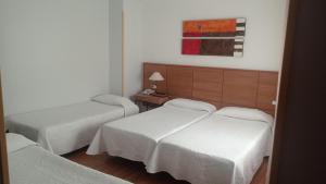 a hotel room with two beds and a table at Molino in Ronda