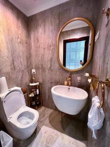 a bathroom with a sink and a toilet and a mirror at شقة ملكيه فاخرة مطله على البحر in Jeddah