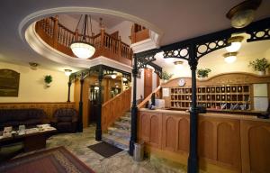 a bar in a pub with a staircase and a lobby at Hotel Pannonia in Miskolc